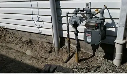 Gas meter and newly installed gas piping on the side of a house