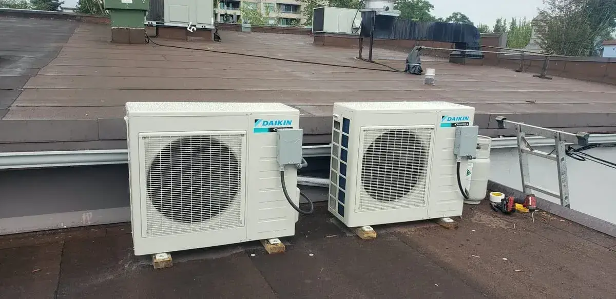 Two Daikin ductless mini-split outdoor units on a flat roof