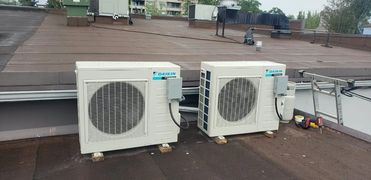 Two Daikin ductless mini-split outdoor units on a flat roof