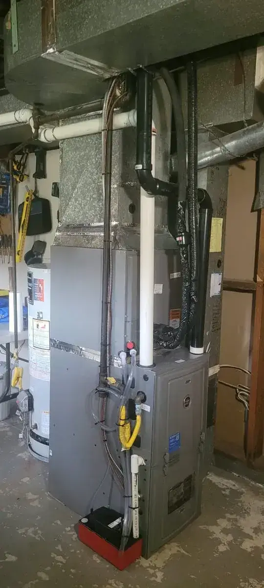 Dual-fuel furnace and heat pump coil with a condensate pump, beside a hot water tank