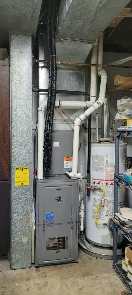 Furnace with a heat pump coil and new PVC venting next to a gas hot water tank